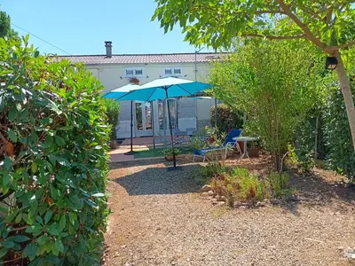 a patio with an umbrella and a table and chairs at Corse-San Giuliano-maison- 2 mn de la plage in San-Giuliano