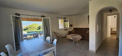 a kitchen and living room with a table and a couch at T3 Dolce & Vita A3 avec Piscine et vue Montagnes in Propriano