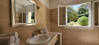 a bathroom with a sink and a mirror and a window at T3 Dolce & Vita A3 avec Piscine et vue Montagnes in Propriano