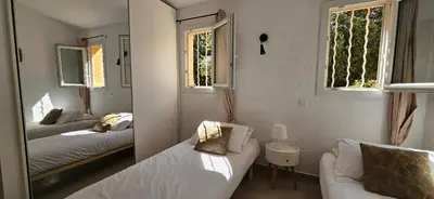 a small bedroom with two beds and a mirror at T3 Dolce & Vita A3 avec Piscine et vue Montagnes in Propriano