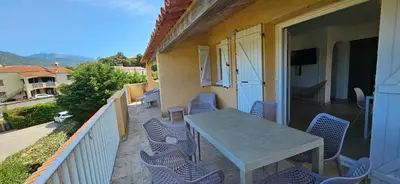 a patio with a table and chairs on a balcony at T3 Dolce & Vita A3 avec Piscine et vue Montagnes in Propriano