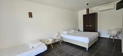 a bedroom with two beds and a chair in it at Studio Dolce & Vita C2 vue mer avec piscine in Propriano