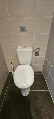 a toilet in a bathroom with a sign on the wall at Studio Dolce & Vita C2 vue mer avec piscine in Propriano