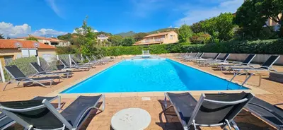 a swimming pool with lounge chairs and a swimming pool at Studio Dolce & Vita C2 vue mer avec piscine in Propriano