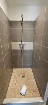 a bathroom with a shower with a towel on the floor at Studio Dolce & Vita C2 vue mer avec piscine in Propriano