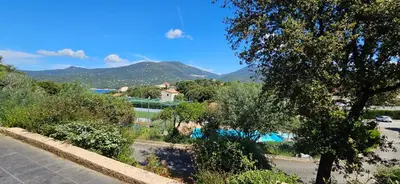a view of a street with trees and a mountain at Studio Dolce & Vita C2 vue mer avec piscine in Propriano
