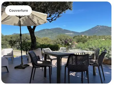 a table with chairs and an umbrella on a patio at T3 Dolce & Vita D5 avec Piscine et vue Montagnes in Propriano