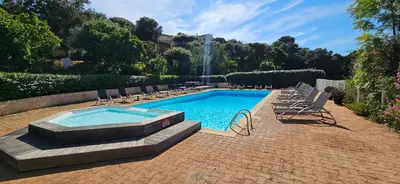 a swimming pool with lounge chairs and a fountain at T3 Dolce & Vita D5 avec Piscine et vue Montagnes in Propriano