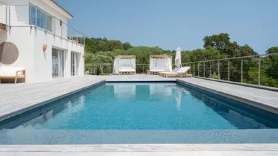 a swimming pool next to a house at Villa avec piscine et vue mer à 230m de la plage in Zonza