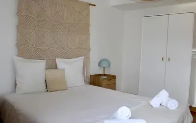 a bedroom with a large white bed with towels on it at Les Hauts du Port-appartement élégant et central in Bonifacio