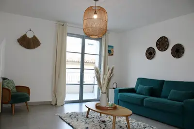 a living room with a blue couch and a table at Les Hauts du Port-appartement élégant et central in Bonifacio