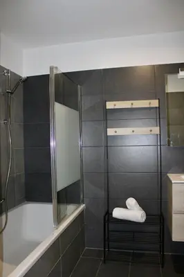 a bathroom with a shower and a tub and a sink at Les Hauts du Port-appartement élégant et central in Bonifacio