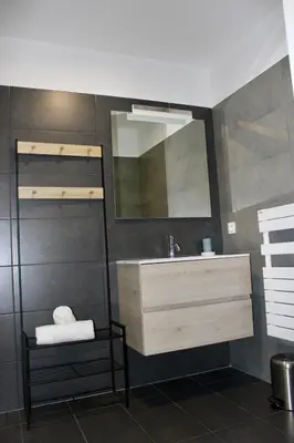 a bathroom with a sink and a mirror at Les Hauts du Port-appartement élégant et central in Bonifacio