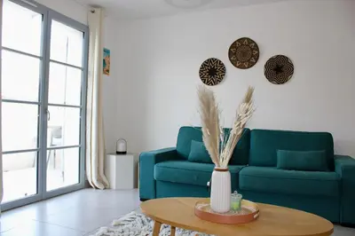 a living room with a blue couch and a table at Les Hauts du Port-appartement élégant et central in Bonifacio
