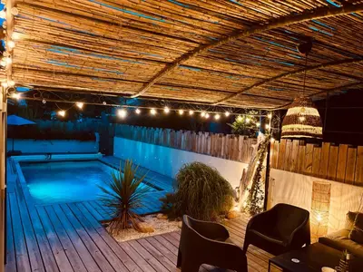 a patio with a swimming pool with lights and chairs at Villa Saint-Cyprien Corse in Lecci