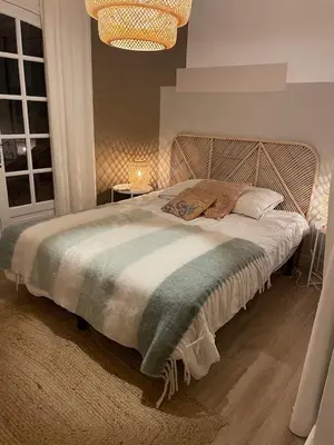 a bedroom with a large bed with a wooden headboard at Villa Saint-Cyprien Corse in Lecci