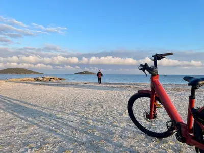 a bike parked on the beach with a person in the background at Villa Saint-Cyprien Corse in Lecci