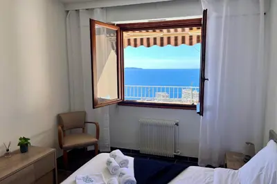 a bedroom with a window with a view of the ocean at Dany - Apartment with large balcony and sea view in Ajaccio