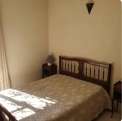 a bedroom with a bed and a lamp on a table at Appartement Saltare Rivière & maquis in Manso