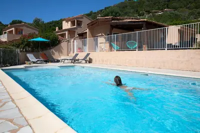 a person swimming in a swimming pool at Résidence U LATONU in Porto-Vecchio