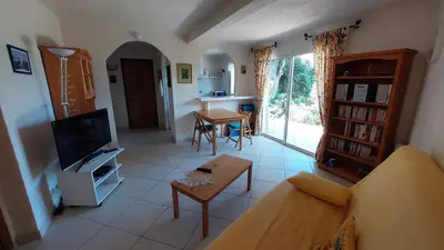 a living room with a couch and a table at 2 pièces accès direct plage in Sainte-Lucie de Porto-Vecchio