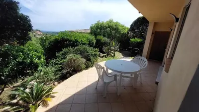 a patio with a table and chairs on a balcony at 2 pièces accès direct plage in Sainte-Lucie de Porto-Vecchio