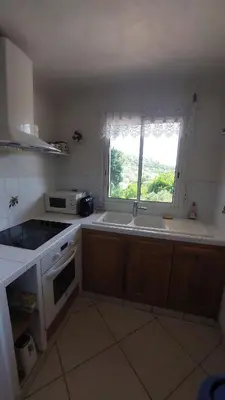 a kitchen with a sink and a window in it at 2 pièces accès direct plage in Sainte-Lucie de Porto-Vecchio