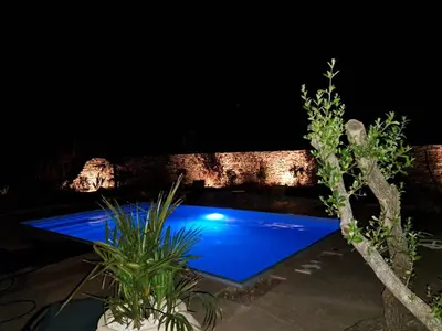 a swimming pool lit up at night at chalet 3 au cœur du maquis in Bonifacio