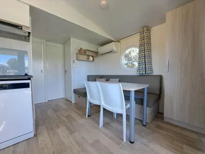 a kitchen and dining room with a table and chairs at chalet 3 au cœur du maquis in Bonifacio