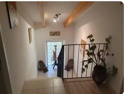 a room with a staircase and a vase with a plant at Appartement Paglia Orba Rivière & maquis in Manso
