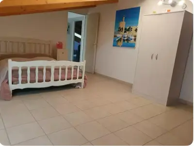 a bedroom with a crib and a bed in a room at Appartement Paglia Orba Rivière & maquis in Manso