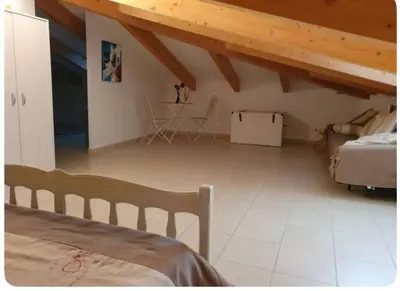 a bedroom with a bed and a table in a room at Appartement Paglia Orba Rivière & maquis in Manso