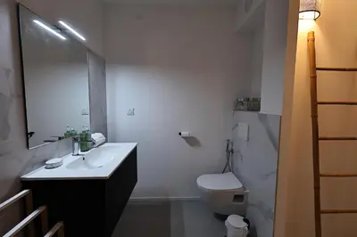 a white bathroom with a sink and a toilet at U Speronu - Plage Privée & Piscine Chauffée in Pianottoli-Caldarello