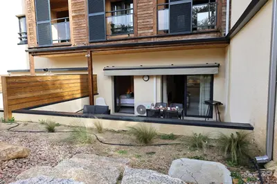 a house with a balcony with a table on it at U Speronu - Plage Privée & Piscine Chauffée in Pianottoli-Caldarello