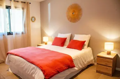 a bedroom with a large bed with two red pillows at Casa Cavu di Santa Lucia in Sainte-Lucie de Porto-Vecchio