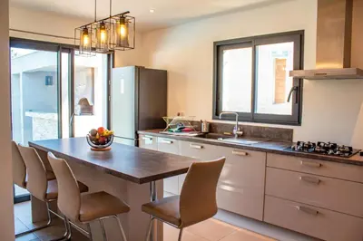 a kitchen with a table and chairs in a kitchen at Casa Cavu di Santa Lucia in Sainte-Lucie de Porto-Vecchio