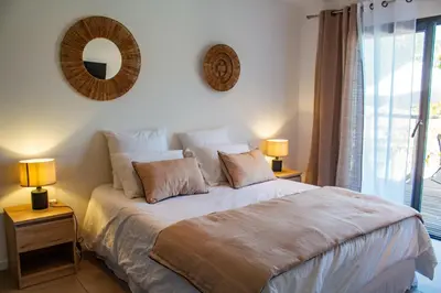 a bedroom with a bed with two lamps and a window at Casa Cavu di Santa Lucia in Sainte-Lucie de Porto-Vecchio