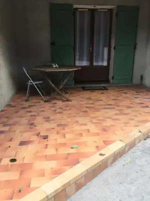 a room with a wooden floor with a table and green doors at Quadrale in Sotta