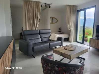 a living room with a couch and a table at Villa Panoramique in Alata