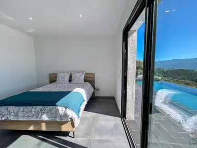 a bedroom with a bed and a swimming pool at Villa Panoramique in Alata