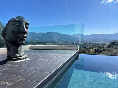 a statue of a head sitting on the edge of a pool at Villa Panoramique in Alata