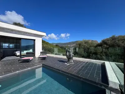 a swimming pool with a statue next to a house at Villa Panoramique in Alata