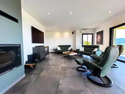 a living room with chairs and a flat screen tv at Villa Panoramique in Alata