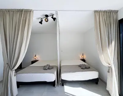 two twin beds in a room with curtains at Villa Panoramique in Alata