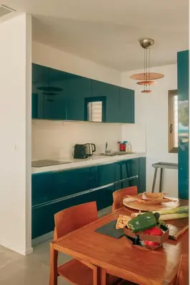a kitchen with green cabinets and a wooden table at Elegant Architect-Designed Home In Upper Corsica in Taglio-Isolaccio