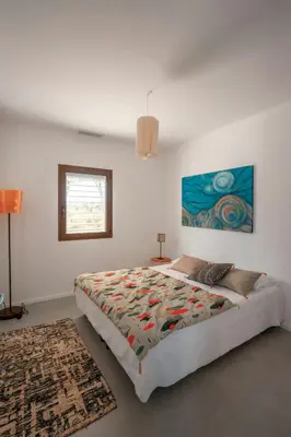 a bedroom with a bed and a painting on the wall at Elegant Architect-Designed Home In Upper Corsica in Taglio-Isolaccio