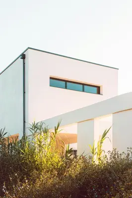 a white building with plants in front of it at Elegant Designer Home By The Sea In Corsica in Taglio-Isolaccio