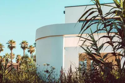 a building with palm trees in front of it at Elegant Designer Home By The Sea In Corsica in Taglio-Isolaccio
