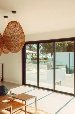 a living room with a table and a large window at Elegant Designer Home By The Sea In Corsica in Taglio-Isolaccio