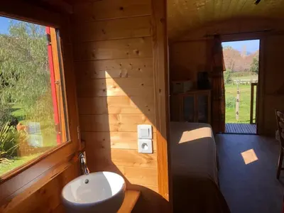 a bathroom with a sink in a wooden cabin at Le nid des crinières vagabondes in Oletta